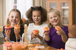 Girls in Halloween costumes decorating cupcakes