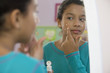Hispanic girl putting on acne cream