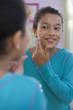 Hispanic girl putting on acne cream