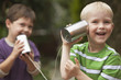 Caucasian boys playing with tin can telephone