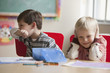 Caucasian boy wiping his nose in classroom