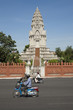 People on scooters near ornate temple