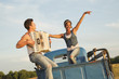 Man playing accordion for girlfriend in back of truck