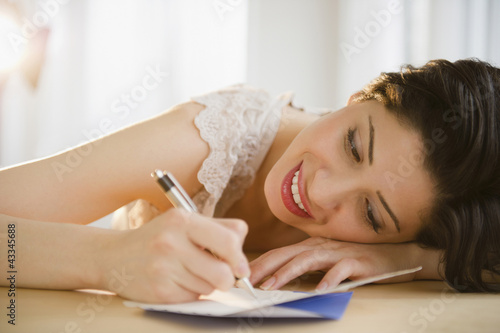 Photo: Mixed race woman writing on birthday card Mixed race woman writing on birthday card