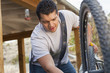 Hispanic man repairing his bicycle