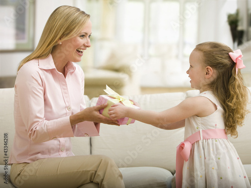Photo: Caucasian daughter giving mother a gift Caucasian daughter giving mother a gift