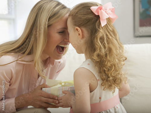 Photo: Caucasian daughter giving mother a gift Caucasian daughter giving mother a gift