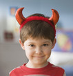 Smiling Caucasian boy in devil costume