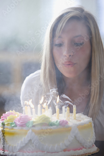 Photo: Caucasian teenage girl blowing out birthday candles Caucasian teenage girl blowing out birthday candles
