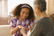 Grandmother painting granddaughter's fingernails