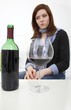 Woman drinking wine (focus on bottle)