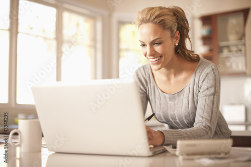 Photo: Hispanic woman typing on laptop Hispanic woman typing on laptop
