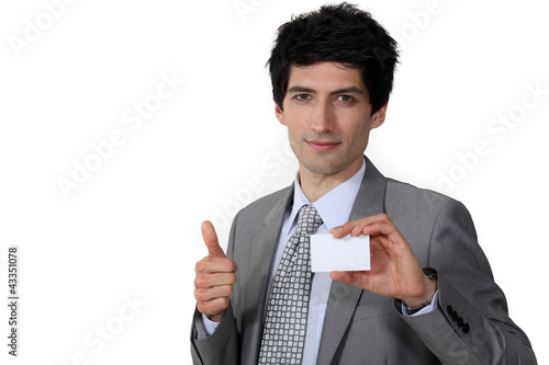Photo: Businessman giving the thumb's up and holding a business card Businessman giving the thumb's up and holding a business card