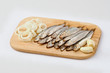 Salted sprats on cutting board with fresh onion
