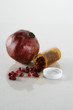 Pill bottle full of pomegranate seeds next to pomegranate