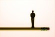 Figure of businessman balanced on pencil