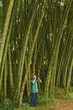 Hispanic boy standing in woods with binoculars