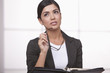 Serious Hispanic businesswoman thinking