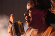 Black woman singing into microphone