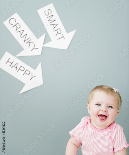 Photo: Caucasian baby near arrows reading cranky, smart and happy Caucasian baby near arrows reading cranky, smart and happy