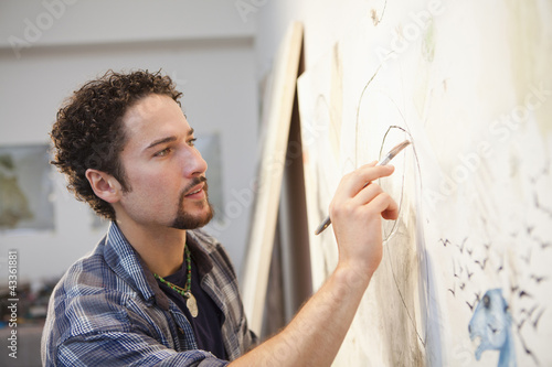 Photo: Mixed race artist painting in studio Mixed race artist painting in studio