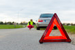 Junge Frau mit Warndreieck auf Straße