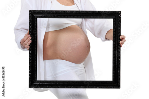 Foto: Pregnant woman holding a frame around her belly Pregnant woman holding a frame around her belly