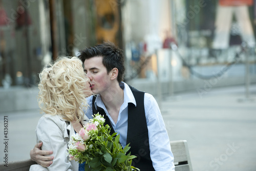 Photo: Caucasian couple kissing on bench Caucasian couple kissing on bench