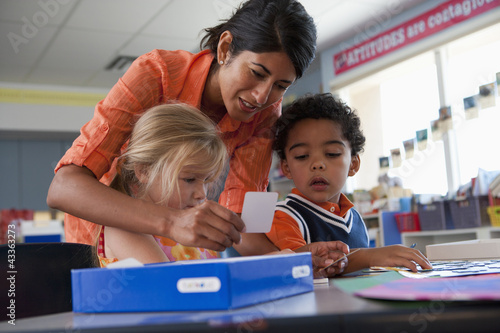 Photo: Teacher helping students in classroom Teacher helping students in classroom