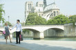 Caucasian couple walking along city river near Notre Dame