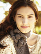 Photo: Close up of gorgeous woman in nature wearing a gray knit scarf smiling at the camera Close up of gorgeous woman in nature wearing a gray knit scarf smiling at the camera