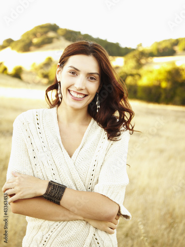 Photo: Beautiful happy woman walking in nature wearing a long sweater laughing Beautiful happy woman walking in nature wearing a long sweater laughing