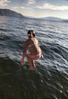 Caucasian girl in bikini jumping into lake