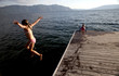 Photo: Caucasian girl jumping from pier into lake Caucasian girl jumping from pier into lake