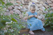 Serious Caucasian girl picking vegetables in garden