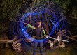 Black woman making blue light streaks in air