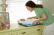 Caucasian mother changing baby daughter