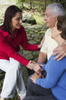 Hispanic woman giving senior Hispanic couple bad news