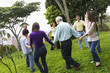 Hispanic family holding hands in a circle outdoors