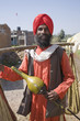 Mixed race man in turban carrying bags on shoulders