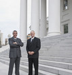 Smiling businessmen standing near steps