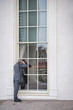 Caucasian businessman peering into window