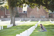 Caucasian girl putting flag on grave in cemetery