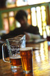 Pitcher and pint of beer on bar