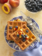 Wheat flour waffles served with blueberry and peach garnish