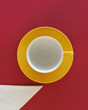 Empty coffee cup and saucer with napkin, top view