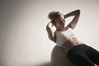Caucasian woman doing sit-ups on exercise ball