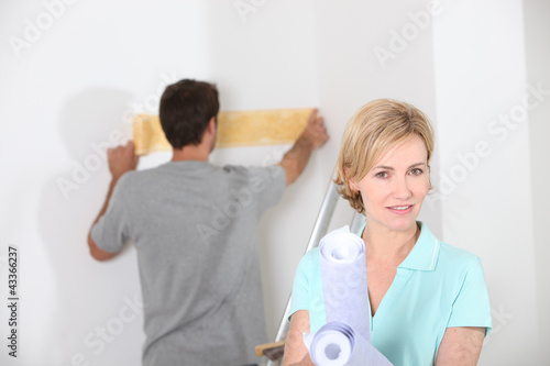 Photo: Couple preparing to wallpaper a white room Couple preparing to wallpaper a white room