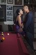 Glamorous couple leaning on pool table kissing