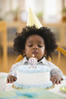 African American boy blowing out birthday candle